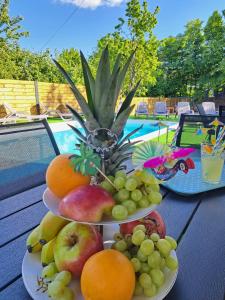 two plates of fruit on a table next to a pool at Apartments Villa Mavi Plitvice in Drežnik Grad +25 photos