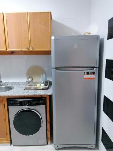 a kitchen with a refrigerator and a microwave at Résidences nour nador in Nador