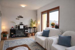 a living room with two white couches and a window at Edi in Sarajevo
