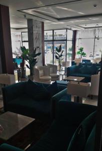 a living room with blue couches and tables and chairs at Garden Melenium - Jazan in Jazan