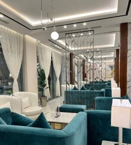 a living room with blue couches and a table at Garden Melenium - Jazan in Jazan