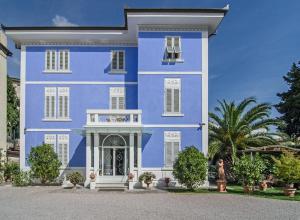 Una casa azul con persianas blancas. en Lucca in Azzurro Maison de Charme, en Lucca