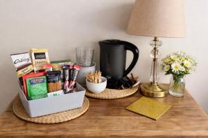 a table with a coffee maker and a box of snacks at Bed for the night, Close to Beach, Shops , Train in St. Leonards
