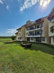 an apartment building with picnic tables in the yard at Seaside Dream in Dolen Bliznak