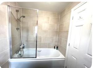 a bathroom with a tub and a shower with a glass door at 3 Bed Home, Exeter, Devon in Countess Wear +18 photos