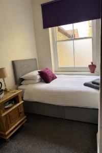 a bedroom with a bed with a window and a pillow at Bed for the night, Close to Beach, Shops , Train in St. Leonards