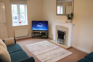 a living room with a tv and a fireplace at 3 Bed Home, Exeter, Devon in Countess Wear