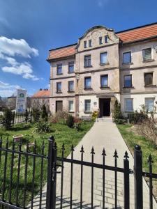 an old building with a fence in front of it at DORMAR I Apartament in Wałbrzych