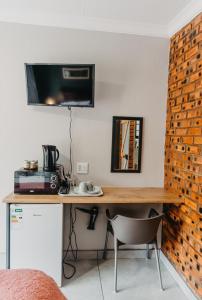 a room with a desk with a television on the wall at Adriaan Place in Bethlehem +16 photos