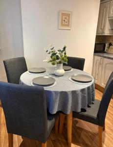 a dining room table with a blue table cloth on it at Cosy Townhouse in Central Leamington with parking in Leamington Spa