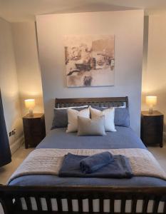 a bedroom with a large bed with pillows and two lamps at Cosy Townhouse in Central Leamington with parking in Leamington Spa