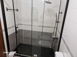 a shower with a glass door in a bathroom at T1 Universidade Açores in Ponta Delgada