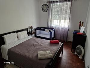 a bedroom with a bed and a window with a fan at T1 Universidade Açores in Ponta Delgada