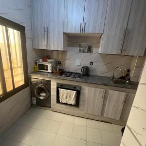 a kitchen with a washing machine and a microwave at World Prestige Properties in Dakar +5 photos