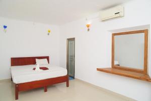 a room with a bed and a mirror on the wall at Ilamperuma Bungalow in Weligama +25 photos