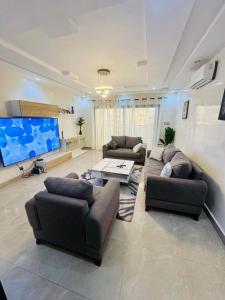 a living room with two couches and a flat screen tv at World Prestige Properties in Dakar