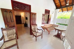 a living room with furniture and a table and chairs at Ilamperuma Bungalow in Weligama