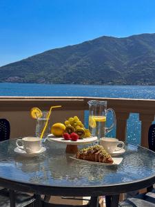 a table with two plates of food and drinks on a balcony at Apartments Stella del Mare in Risan