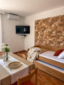 a room with two beds and a table and a tv at Apartments Stella del Mare in Risan