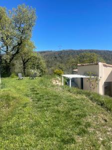 a house on a hill with a bench in the grass at Le Chant des Arbres in Grane