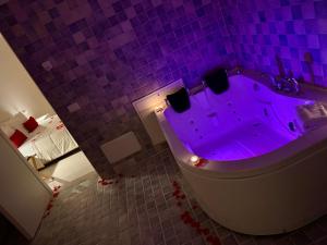 a purple bathroom with a tub with a purple lighting at Lamapulia in Torre a Mare +42 photos