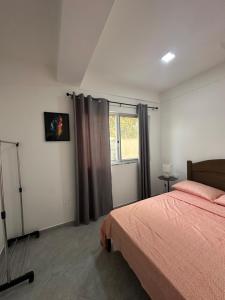 a bedroom with a bed and a window at Quarto individual- Espaço Casa Mendes in Praia +9 photos