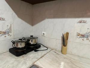 two pots on top of a stove in a kitchen at Quarto individual- Espaço Casa Mendes in Praia