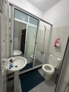 a bathroom with a toilet and a sink at Quarto individual- Espaço Casa Mendes in Praia