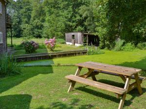 a wooden picnic table sitting in the grass in a yard at The Wherry Arch in Neatishead
