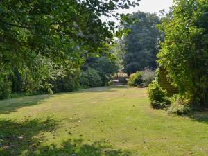 a large grassy yard with stairs and trees at The Wherry Arch in Neatishead