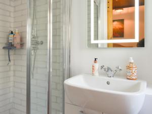 a white bathroom with a sink and a shower at South Downs Lodge in Soberton