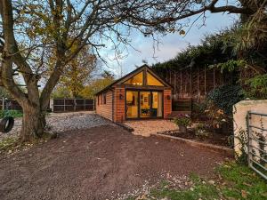 a small house in a yard with a tree at South Downs Lodge in Soberton
