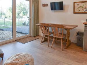 a dining room with a table and chairs and a sliding glass door at South Downs Lodge in Soberton +7 photos