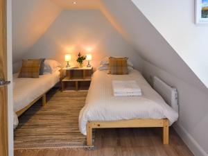 two beds in a attic room with two lamps at Bonnie Cottage - Uk40057 in Aberfeldy