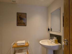 a bathroom with a white sink and a mirror at Bonnie Cottage - Uk40057 in Aberfeldy