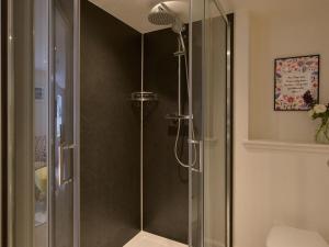a shower with a glass door in a bathroom at Bonnie Cottage - Uk40057 in Aberfeldy +3 photos