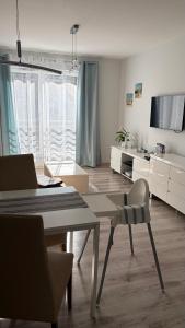 a white living room with a table and chairs at LM Apartamenty Mariacka Stare Miasto in Szczecin