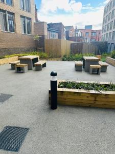 a group of benches and tables in a courtyard at Stylish 2 bedroom modern apartment central to Eccles in Manchester +3 photos