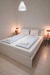 a large white bed in a room with two tables at Panzió Apartments in Budapest