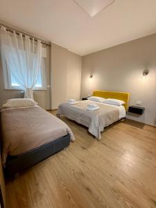 a bedroom with two beds and a window at Sottovento B&B in Trani