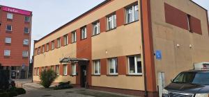 ein Gebäude, vor dem ein Auto geparkt ist in der Unterkunft Rest Hostel Airport Modlin in Nowy Dwór Mazowiecki