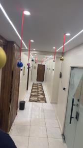 a long hallway with red lights and a tile floor at Tua Pyramids View in Cairo