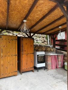an outdoor kitchen with wooden cabinets and a stove at Albergue La HERMIDA in La Hermida