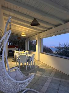 a patio with a table and chairs and a large window at Relais Villa Ettore in Barano d'Ischia