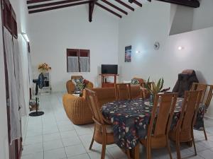 a living room with a table and a couch at Villa DAMARRE in Petit-Bourg
