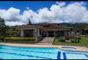 a house with a swimming pool in front of it at La Mona in Calima