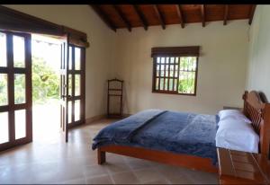 a bedroom with a bed in a room with windows at La Mona in Calima +18 photos