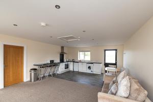 a living room with a couch and a kitchen at Copperbeech Farm Cottages in Maze