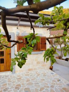 a building with wooden shutters on the side of it at Small Stone Cottage in Virpazar