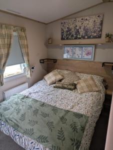 a bedroom with a bed with a green comforter at Arnside abode in Morecambe